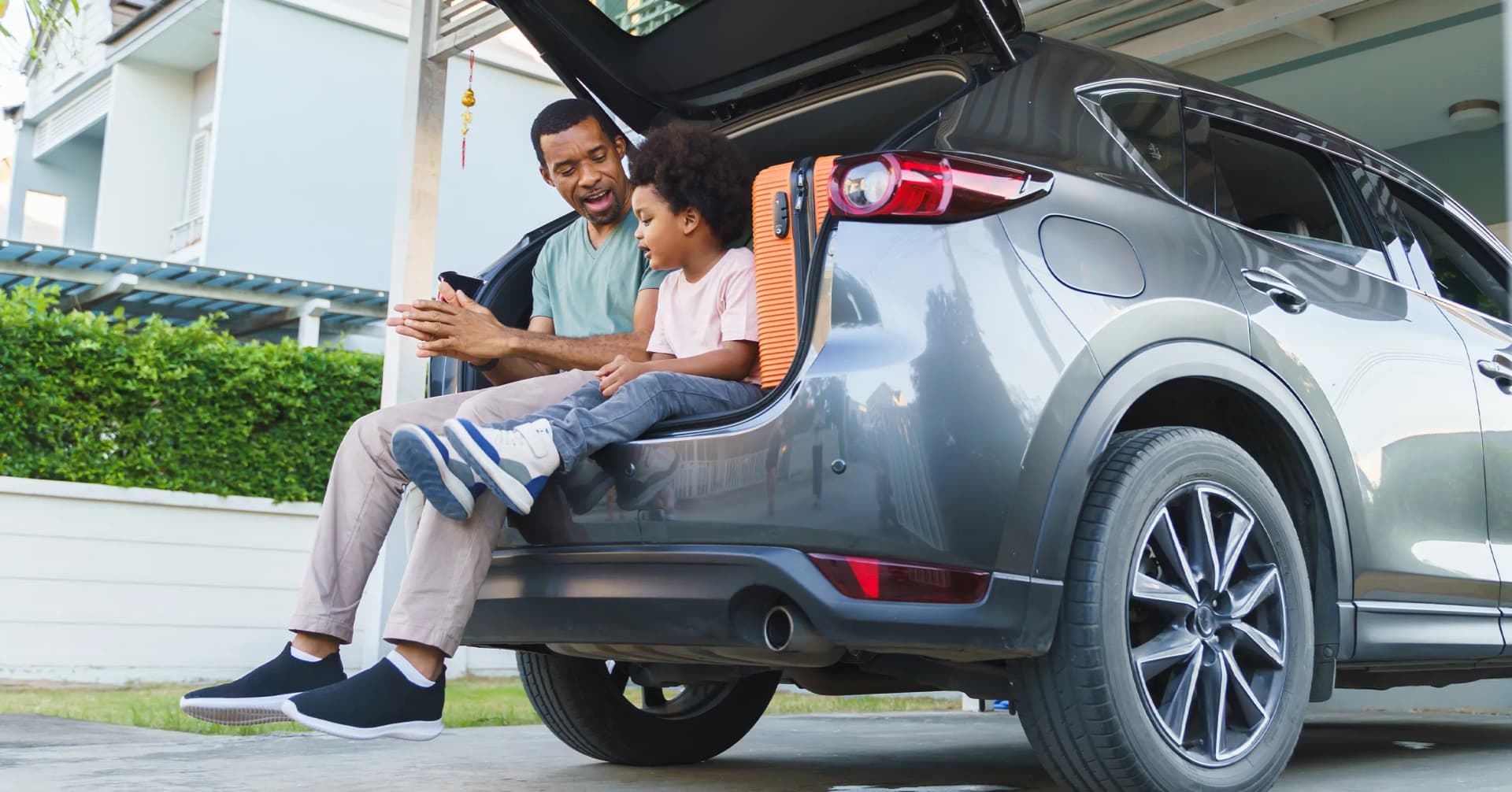 Father and son sitting on an open tailgate.