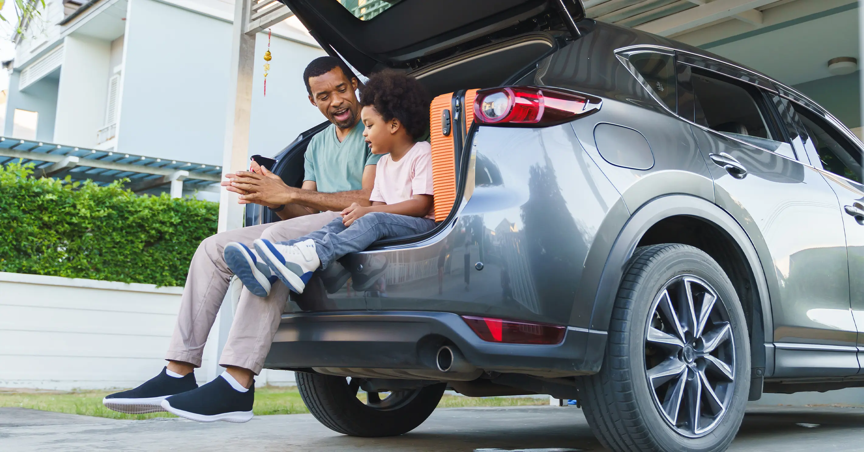Father and son sitting on an open tailgate.