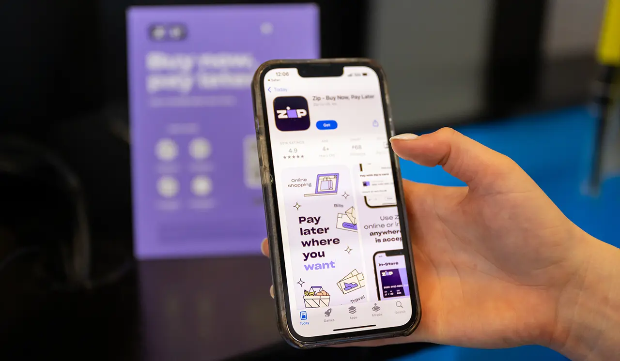 Customer holding their phone with the ZIP mobile app displaying.
