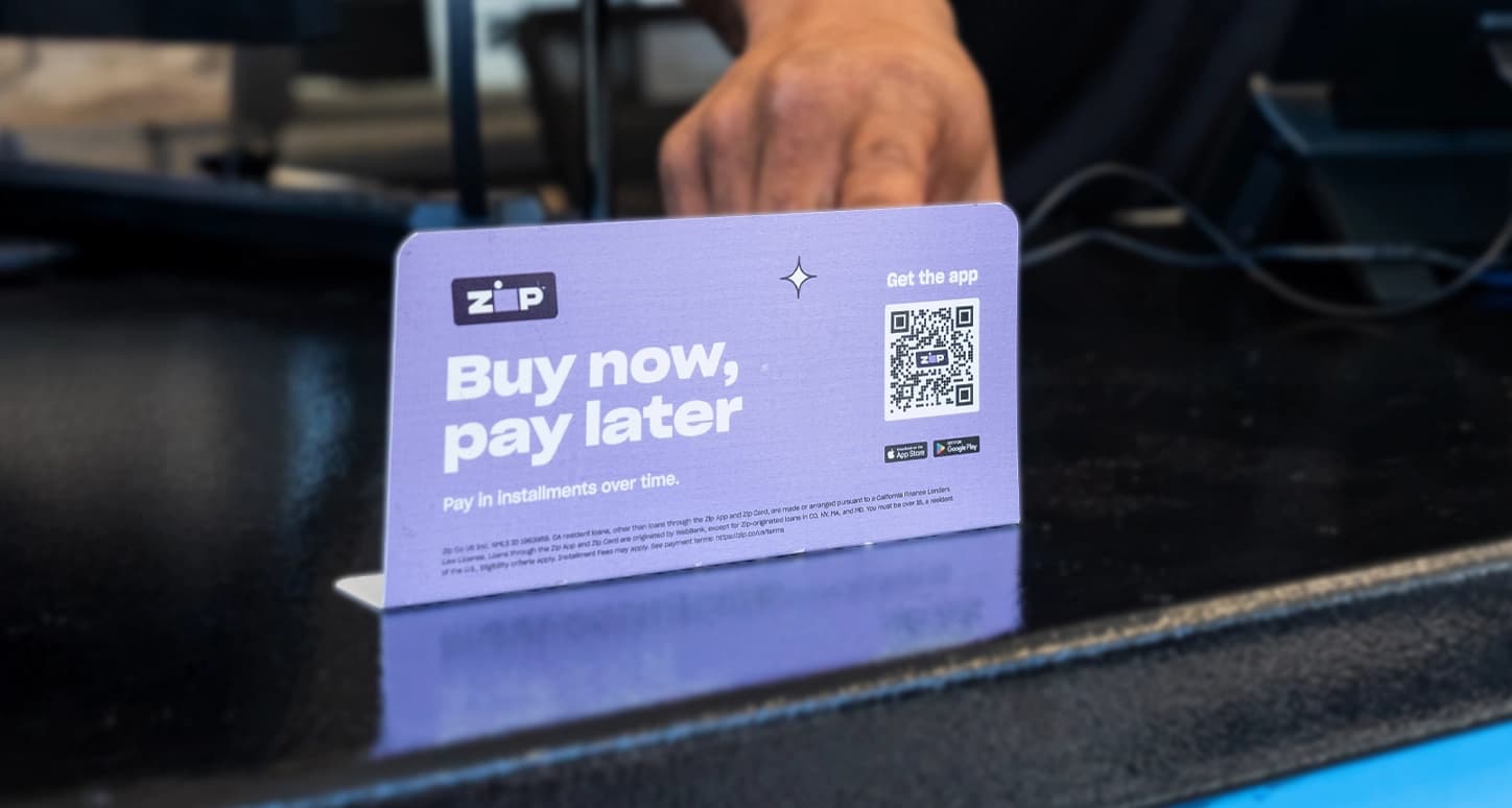 Technician pointing to Buy now, pay later sign.