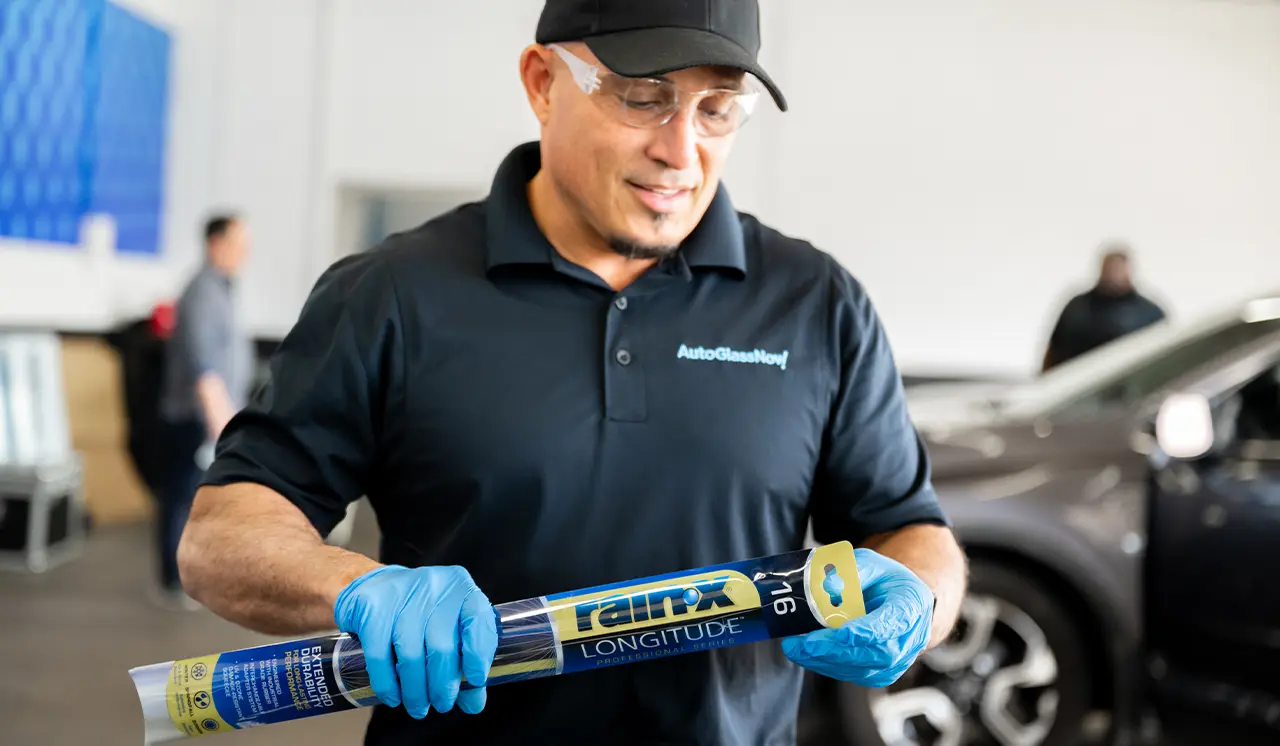 Technician holding brand new windshield wipers